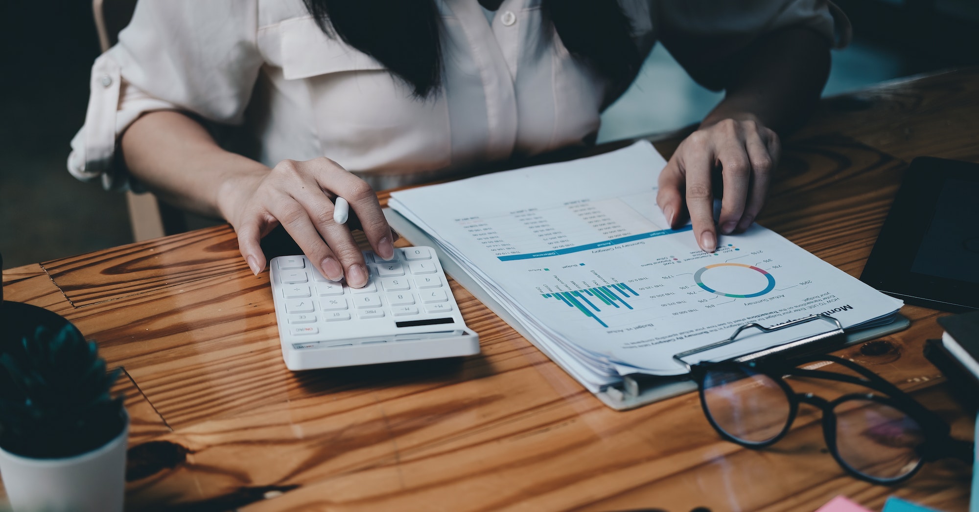 businesswoman working on desk with calculator with financial chart report in office. concept businesswoman working on desk with calculator with financial chart report in office. concept