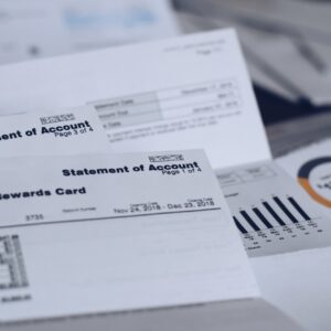 Scattered multiple utility bills and credit card statements on a desk. Post holiday debt