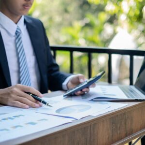 Young Asian businessman financial market analyst sits at their desks and calculate financial graphs